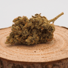 Fleur de CBD RAINBOW 100% naturelle posée sur une tranche de bois, cultivée en hydroponie Indoor en Suisse, avec un taux de THC inférieur à 0,3%.