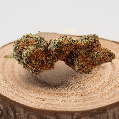 Fleur de CBD BANANA 100% naturelle, cultivée en Indoor, posée sur un support en bois, arômes fruités et sucrés, faible THC <0,3%.
