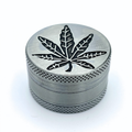 GRINDER METAL 3 PARTIES avec motif feuille de cannabis gravé sur le couvercle, idéal pour broyer les herbes. Accessoire robuste et élégant.