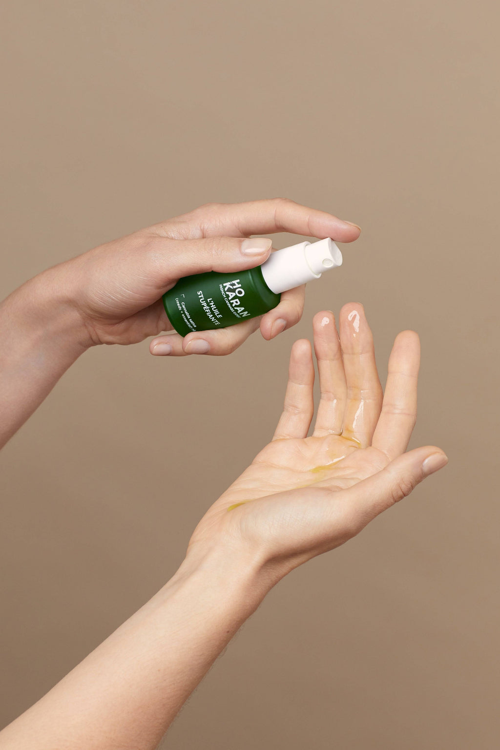 HUILE STUPÉFIANTE HO KARAN 30ML appliquée sur la main, élixir hydratant multi-usage au CBD pour visage, corps et cheveux.