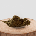 Fleur de CBD SUPER SKUNK cultivée en indoor, posée sur une base en bois. Variété riche en arômes épicés et terreux, idéale pour infusion.