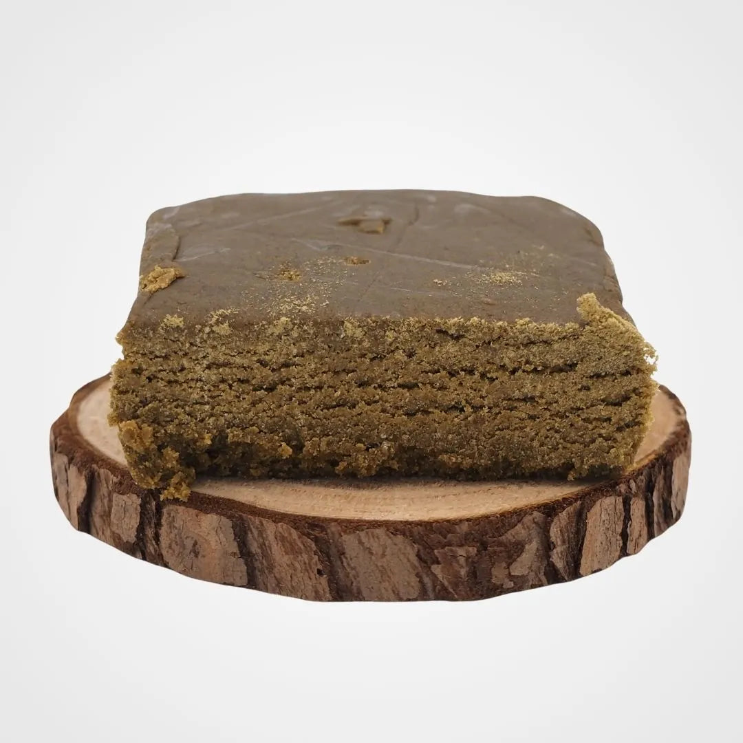 Résine CBD Bubble X 4 française avec 44,4% de CBD, présentée sur une tranche de bois. Produit de qualité supérieure pour bien-être animal.