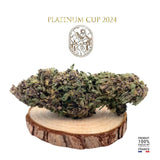 Fleur de CBD LEGENDARY PLATINIUM OG cultivée en serre, 100% naturelle, THC < 0,3%, présentée sur un support en bois. Produit en France.