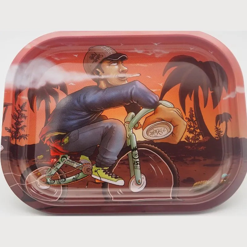 Plateau à rouler en acier avec illustration colorée d'un cycliste sur fond tropical au coucher de soleil, design unique et pratique.